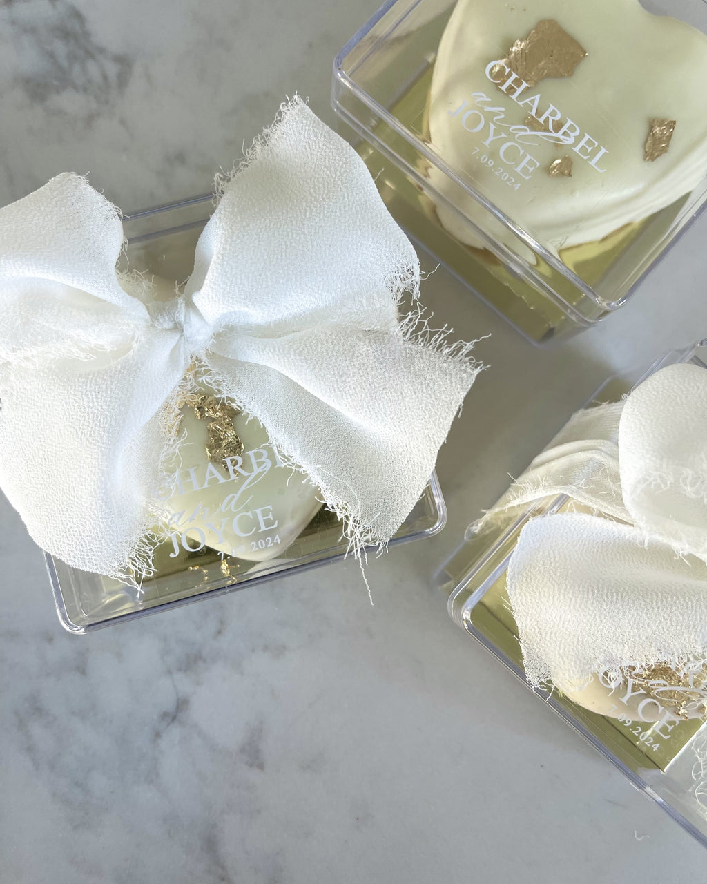Heart ma'amoul with names in a clear acrylic box with a white bow
