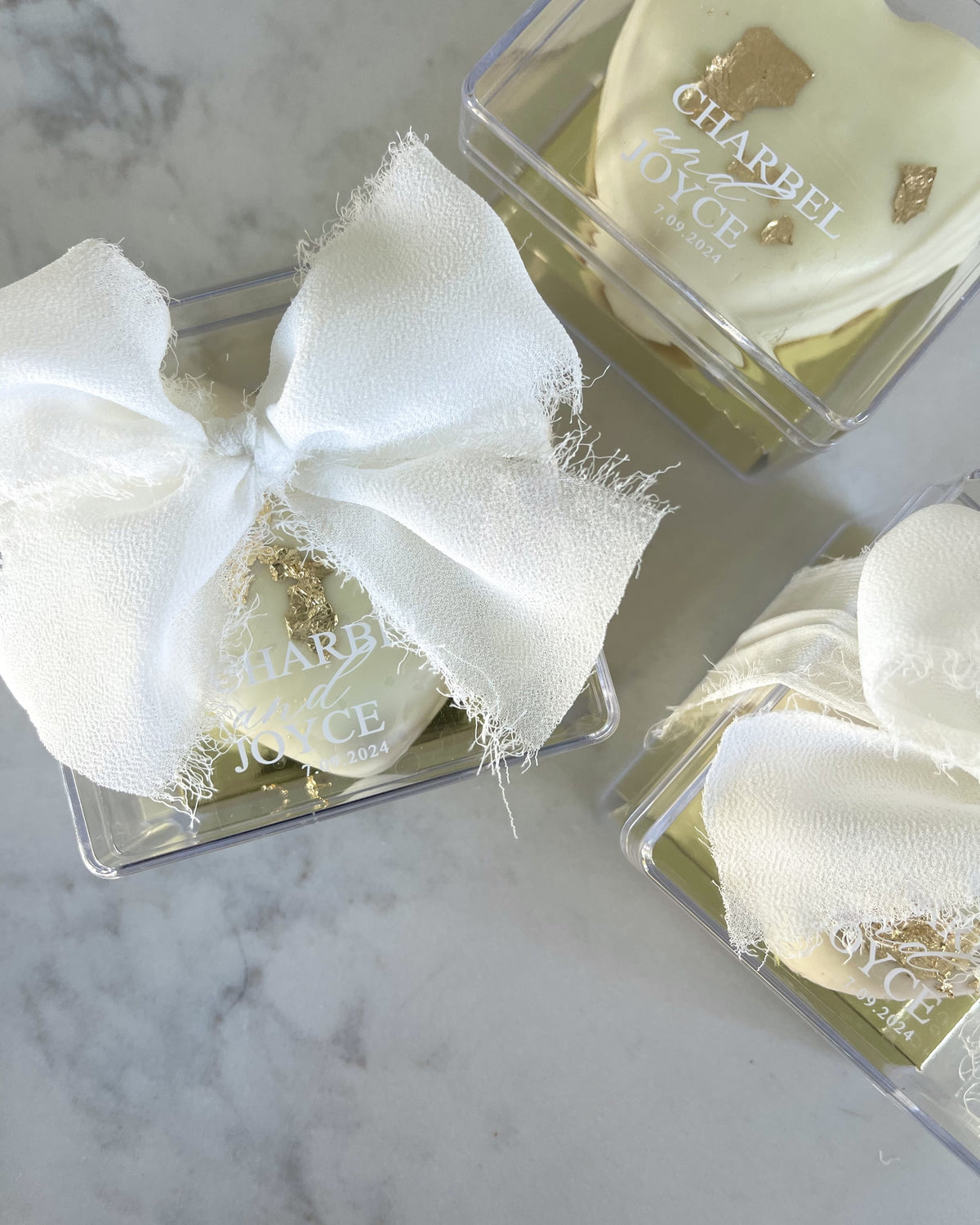 Heart ma'amoul with names in a clear acrylic box with a white bow